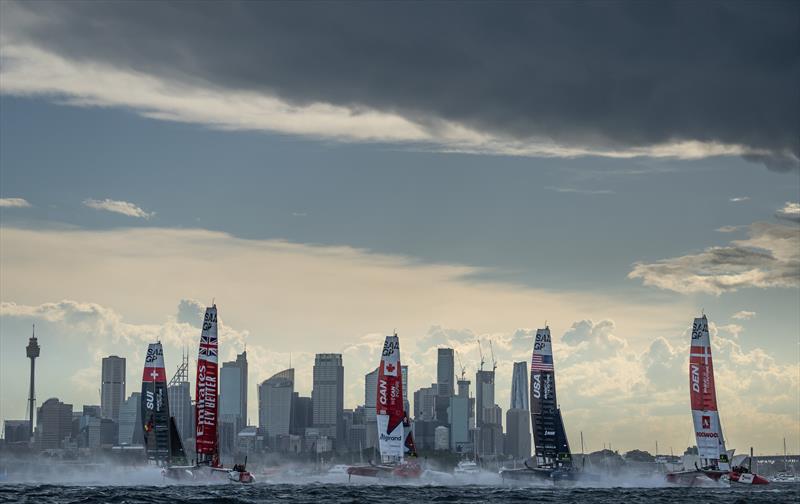 The fleet led by Denmark SailGP Team presented by ROCKWOOL ahead of USA SailGP Team, Canada SailGP Team Emirates Great Britain SailGP Team and Switzerland SailGP Team sail past the skyline on Race Day 1 of the KPMG Australia Sail Grand Prix in Sydney photo copyright Bob Martin for SailGP taken at  and featuring the F50 class
