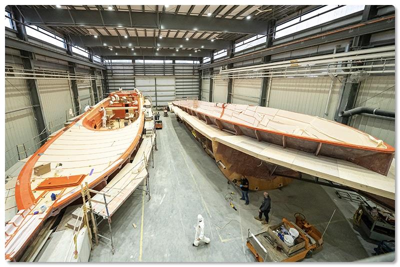 Boatbuilders are shown above preparing the mold for the 90's deckhouse (left), while plant engineering team members (right) make adjustments to the hull mold's turning rig. - photo © Viking Yachts