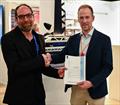 Tom Wolodarsky, Senior Surveyor and Lead Specialist WASP, LR (left) presenting the AiP to Hermen de Jong, Innovation Manager, Rondal at Metstrade 2025 in Amsterdam