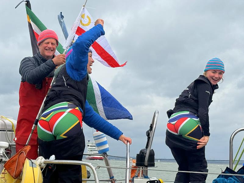 BUMS! Captain Jeremy Bagshaw looks on as chief mate Melissa Du Toit and  youth crew member Aurora Sillars bare bums to proudly show off their South African National undies to the delight of many photo copyright Aïda Valceanu/ OGR2023 taken at Royal Yacht Squadron and featuring the Ocean Globe Race class