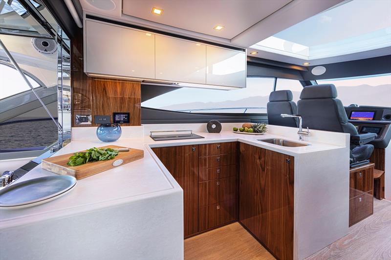 Filled with natural light, the aft galley of Riviera 4600 Sport Yacht features premium appliances beautifully integrated into the handcrafted Riviera joinery of varnished exotic timbers photo copyright Riviera Australia taken at  and featuring the Power boat class